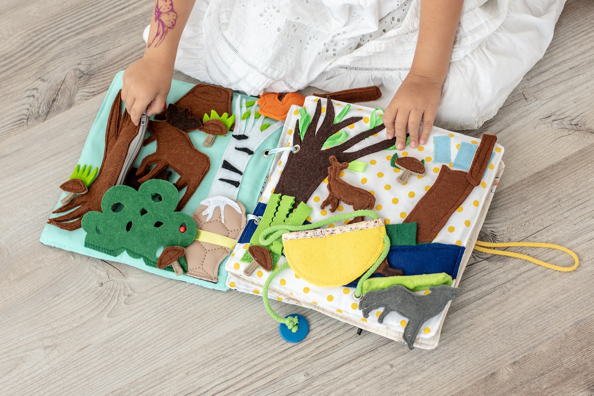 girl-holding-woodland-busy-book-with-felt-animals
