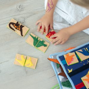 small-girl-playing-puzzle-in-dinosaur-busy-book