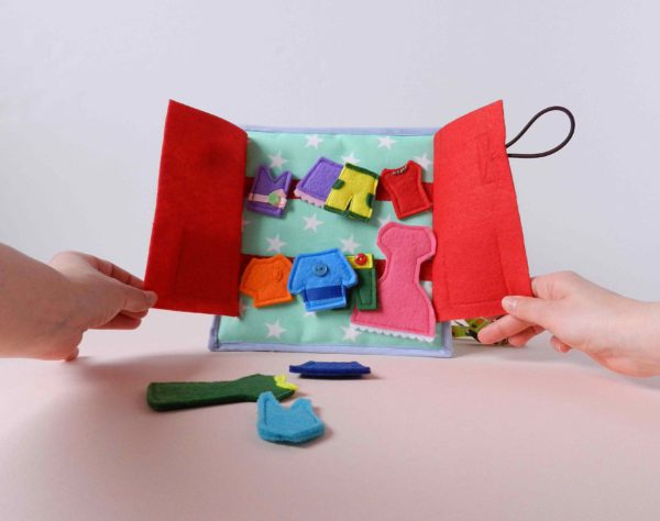 hands-holding-the-quiet-book-page-with-felt-clothes